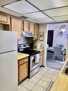 uma cozinha com armários de madeira e um frigorífico branco em Island 1 em Kissimmee
