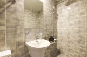 bagno con lavandino, servizi igienici e specchio di Hotel YOU a Yeosu