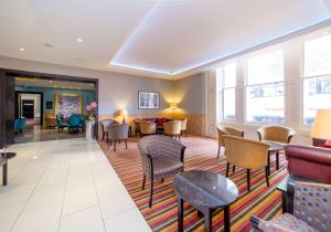 a lobby of a hotel with chairs and tables at DoubleTree by Hilton Hotel London - Marble Arch in London