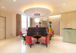 a dining room with a table and red chairs at DoubleTree by Hilton Hotel London - Marble Arch in London
