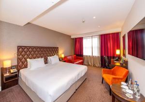 a large hotel room with a bed and chairs at DoubleTree by Hilton Hotel London - Marble Arch in London