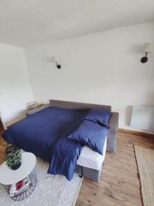 - une chambre avec un lit doté d'oreillers bleus et d'une table dans l'établissement Studio Pra Loup 1500 Les Molanes, à Uvernet