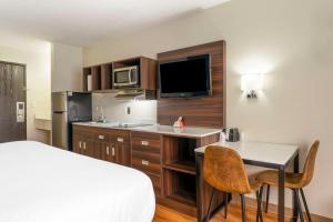 a hotel room with a bed and a desk and a kitchen at Suburban Studios LaVale - Cumberland in La Vale