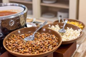 Duas tigelas de comida numa mesa com colheres. em La Quinta by Wyndham Quito em Quito