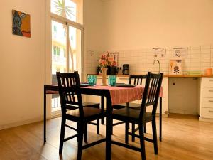 a dining room table with four chairs and a kitchen at By La Rambla Rooms in Barcelona
