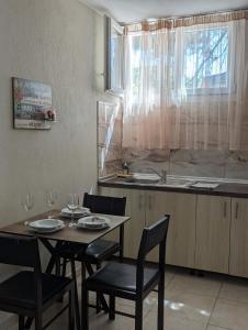 eine Küche mit einem Tisch und Stühlen sowie einem Fenster in der Unterkunft DeniaStella villas in Skala Potamias
