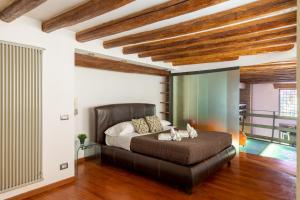 ein Schlafzimmer mit einem großen Bett in einem Zimmer mit Holzdecken in der Unterkunft Santa Cecilia Loft in Rom