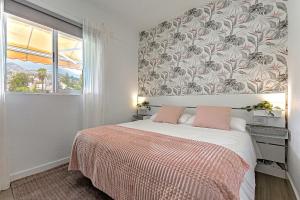 a bedroom with a bed with a floral wallpaper at Vista al Teide y al mar 7 in Puerto de la Cruz