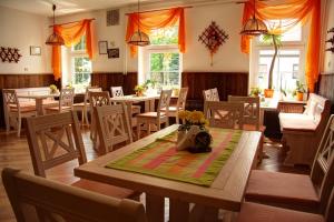 a dining room with tables and chairs and orange curtains at Werners Landgasthaus in Lieskau +12 photos
