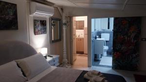 1 dormitorio con 1 cama grande y baño en Green Cottage en Agrigento