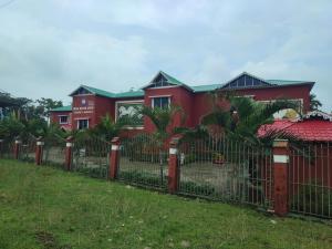 una cerca frente a una casa roja en Maa River View, en Alīpur Duār