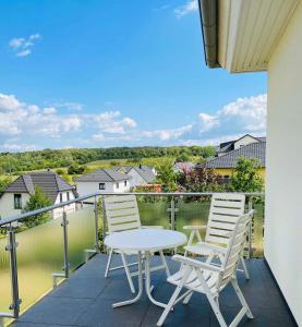 d'une terrasse avec 2 chaises et une table sur un balcon. dans l'établissement Ferienwohnung Sea-Bike-Soul, à Neubrandenbourg