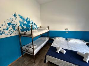 リミニにあるHotel Villa Eneaの青い壁の客室で、二段ベッド2組が備わります。