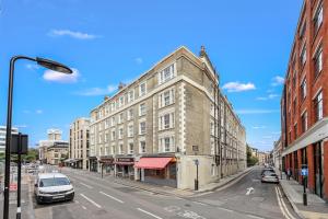 un vecchio edificio in una strada di città con auto parcheggiate di The Old Street Apartment a Londra