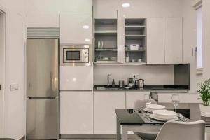 a white kitchen with a table and a refrigerator at RiNa MADRID apartamento1 in Madrid