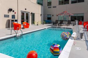 a swimming pool with a ball and an umbrella at Aloft Nashville Airport in Nashville
