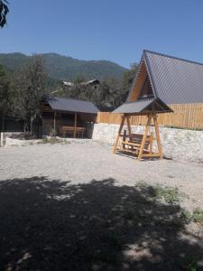 a wooden pavilion with a building with a roof at Cozy Cottage Dilijan Arm in Dilijan
