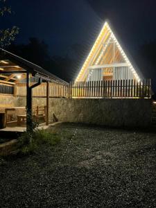 Cozy Cottage Dilijan Arm في ديليجان: منزل مع سقف مضاء في الليل