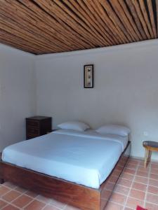 um quarto com uma cama e um tecto em madeira em Mia Safari Lodge and Restaurant em Entebbe