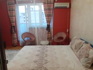 a bedroom with a bed and two chairs at Lepa Kata Centar in Podgorica