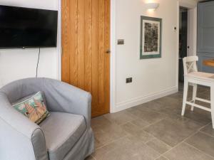 a living room with a couch and a television at Kestrel in Malpas