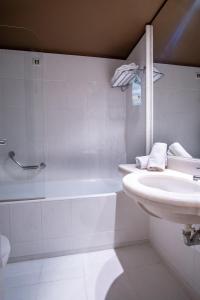 a white bathroom with a sink and a shower at Olympic Hotel in Heraklio Town