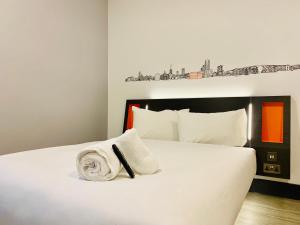 a bedroom with a white bed with a towel on it at easyHotel Ipswich in Ipswich
