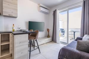 a living room with a table and a tv and a bed at Kunsu's Apartment 5 min walk from St Julians in San Ġwann