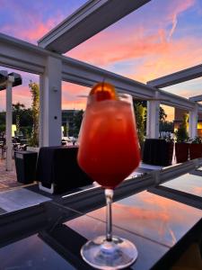 a drink sitting on top of a table with a sunset at The Sydney Hotel in Bologna