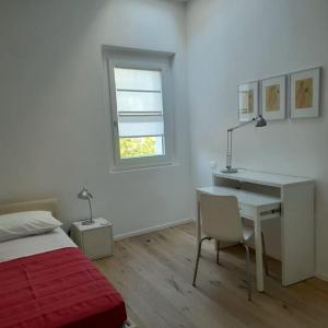 1 dormitorio con escritorio, 1 cama y ventana en Casacciuga, luminosa e centrale casa con giardino, en Pesaro