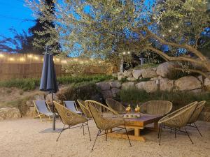 a table and chairs and an umbrella in a yard at Villa de la Tour in Bellegarde