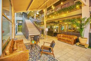 un hall avec des canapés et un escalier dans un bâtiment dans l'établissement Sporting House Hôtel, à Toulouse