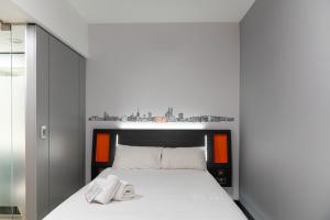 a white bed with two towels on top of it at easyHotel Ipswich in Ipswich