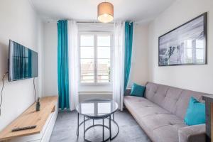 ein Wohnzimmer mit einem Sofa und einem Tisch in der Unterkunft T2 calme proche hyper centre in Limoges