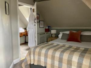 a bedroom with a bed and a dress hanging on the wall at The Bridge House in Bridport