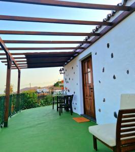 un patio con mesas y sillas y una puerta de madera en Casita Canaria con Vista, en Breña Baja