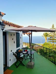 een patio met een tafel en een parasol bij Casita Canaria con Vista in Breña Baja