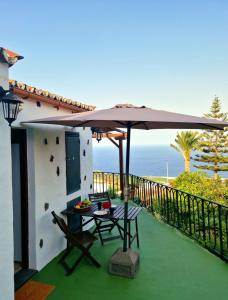 un patio con mesa y sombrilla en Casita Canaria con Vista, en Breña Baja