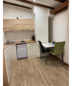 uma pequena cozinha com mesa e cadeiras num quarto em Landhaus Alpenblick em Obsteig