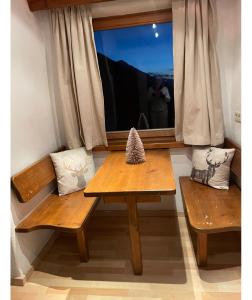 a table and two benches in a room with a window at Landhaus Alpenblick in Obsteig