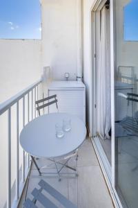 einen weißen Tisch und Stühle auf dem Balkon in der Unterkunft Serafina's Apartment 5 min walk from St Julians in San Ġwann