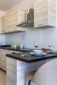 eine Küche mit einer schwarzen Arbeitsplatte und Holzschränken in der Unterkunft Serafina's Apartment 5 min walk from St Julians in San Ġwann