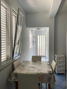 a dining room with a table and chairs and windows at Mariné in Vietri sul Mare