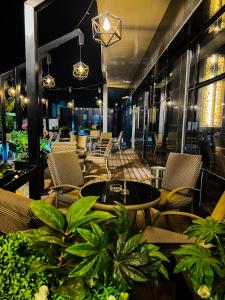 a restaurant with tables and chairs and plants at Y Platinum Hotel in Medina