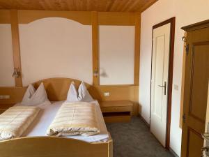 a bedroom with a bed with two pillows on it at Garni Rika in Parcines