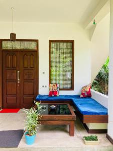 Habitación con sofá azul, mesa y puerta en Mountain seaview Cabanas, en Tangalle