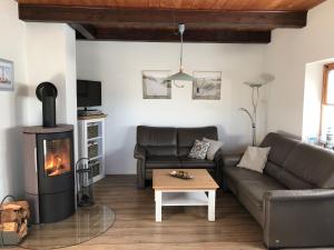 a living room with a couch and a wood stove at Haus am Meer 9082 - Fehmarn in Fehmarn
