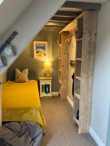 um quarto com uma cama amarela e uma estante de livros em The Bridge House em Bridport