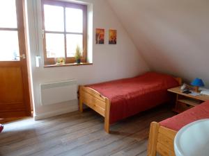 um pequeno quarto com uma cama vermelha e uma janela em Haus am Meer 9082 - Fehmarn em Fehmarn
