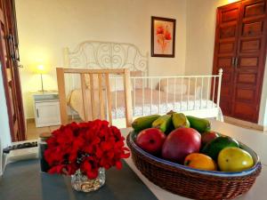 a table with a basket of fruit and a vase of flowers at Casita Canaria con Vista in Breña Baja